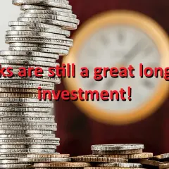 Stacks of coins with the text "Stocks are still a great long-run investment!" overlaid. The image suggests that despite fluctuations, the vtinx stock price can be a solid long-term investment.