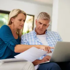 A couple reviews documents and a laptop, discussing their swvxx yield.