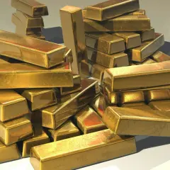 A pile of shiny gold bars, perhaps representing the wealth held by an iaum etf.