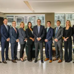 A diverse group of professionals, likely a Morgan Stanley vice president list, pose for a formal photo in a modern office setting.