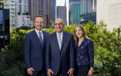 Alan Thomas Morgan Stanley: Three professionals in suits stand before a city skyline.