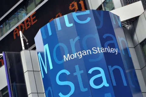 A blue, hexagonal pillar displays the "Morgan Stanley" logo. In the background, an orange digital ticker shows "ADBE" and "91".