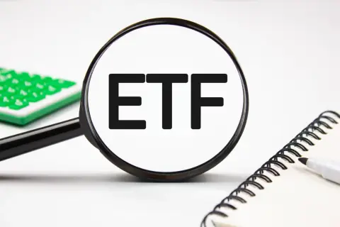 Magnifying glass focuses on "ETF" text, hinting at stock analysis. A calculator and notebook are nearby.