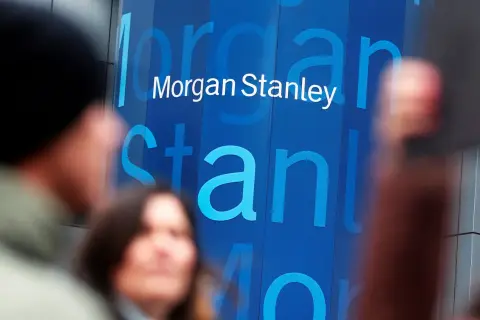 Blurred figures stand before a blue building with the "Morgan Stanley" logo. Investors anticipate the latest Morgan Stanley earnings report.