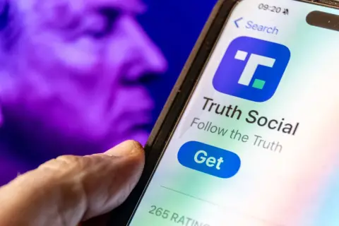 A hand hovers over a smartphone displaying the Truth Social app, with a purple, blurred image of a face in the background, perhaps hinting at the dwac stock price.