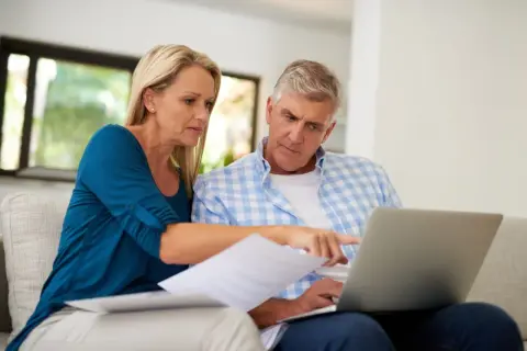 A couple reviews documents and a laptop, discussing their swvxx yield.