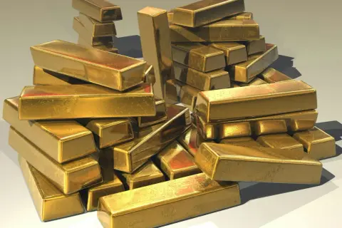 A pile of shiny gold bars, perhaps representing the wealth held by an iaum etf.