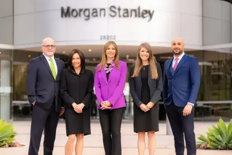 Five professionals stand outside the Morgan Stanley building. The team is ready to help you understand who owns Morgan Stanley and manage your investments.