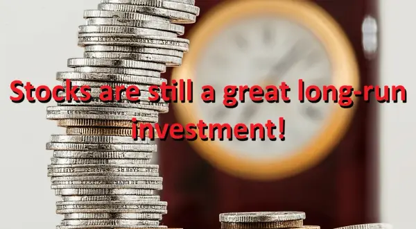 Stacks of coins with the text "Stocks are still a great long-run investment!" overlaid. The image suggests that despite fluctuations, the vtinx stock price can be a solid long-term investment.