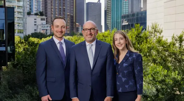 Alan Thomas Morgan Stanley: Three professionals in suits stand before a city skyline.