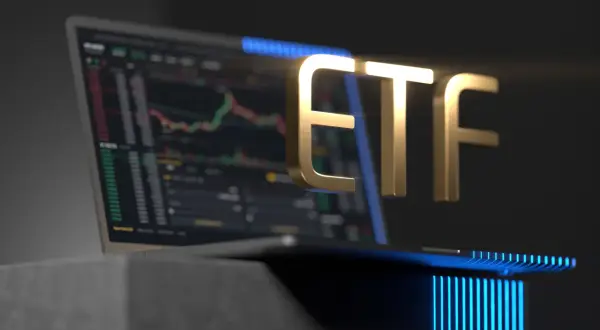 Golden ETF text hovers over a laptop displaying a stock chart, symbolizing investment opportunities.