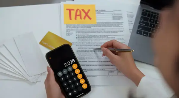 Calculating 401k tax rate implications with a calculator and tax forms.