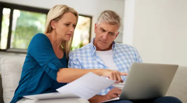 A couple reviews documents and a laptop, discussing their swvxx yield.