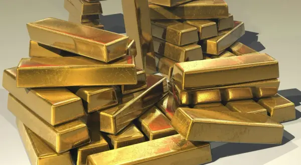 A pile of shiny gold bars, perhaps representing the wealth held by an iaum etf.