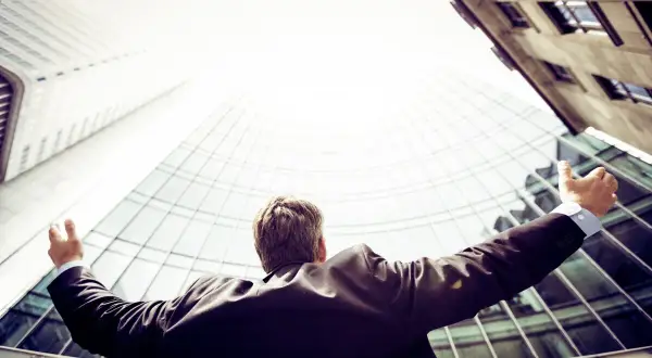 A triumphant Morgan Stanley vice president, arms outstretched, celebrates success against a backdrop of modern skyscrapers.