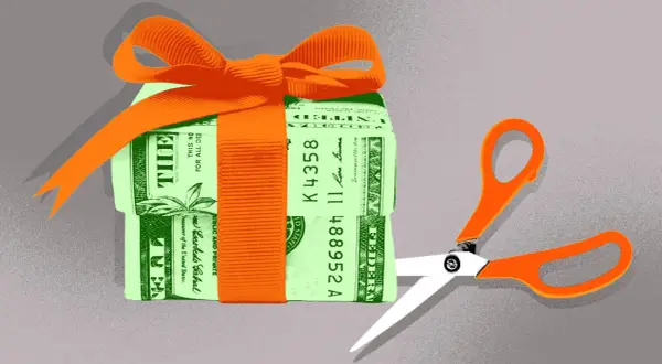 A gift-wrapped stack of money with scissors poised to cut. This symbolizes the potential changes to the gift tax limit in 2026.