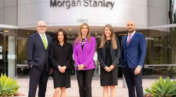 Five professionals stand outside the Morgan Stanley building. The team is ready to help you understand who owns Morgan Stanley and manage your investments.