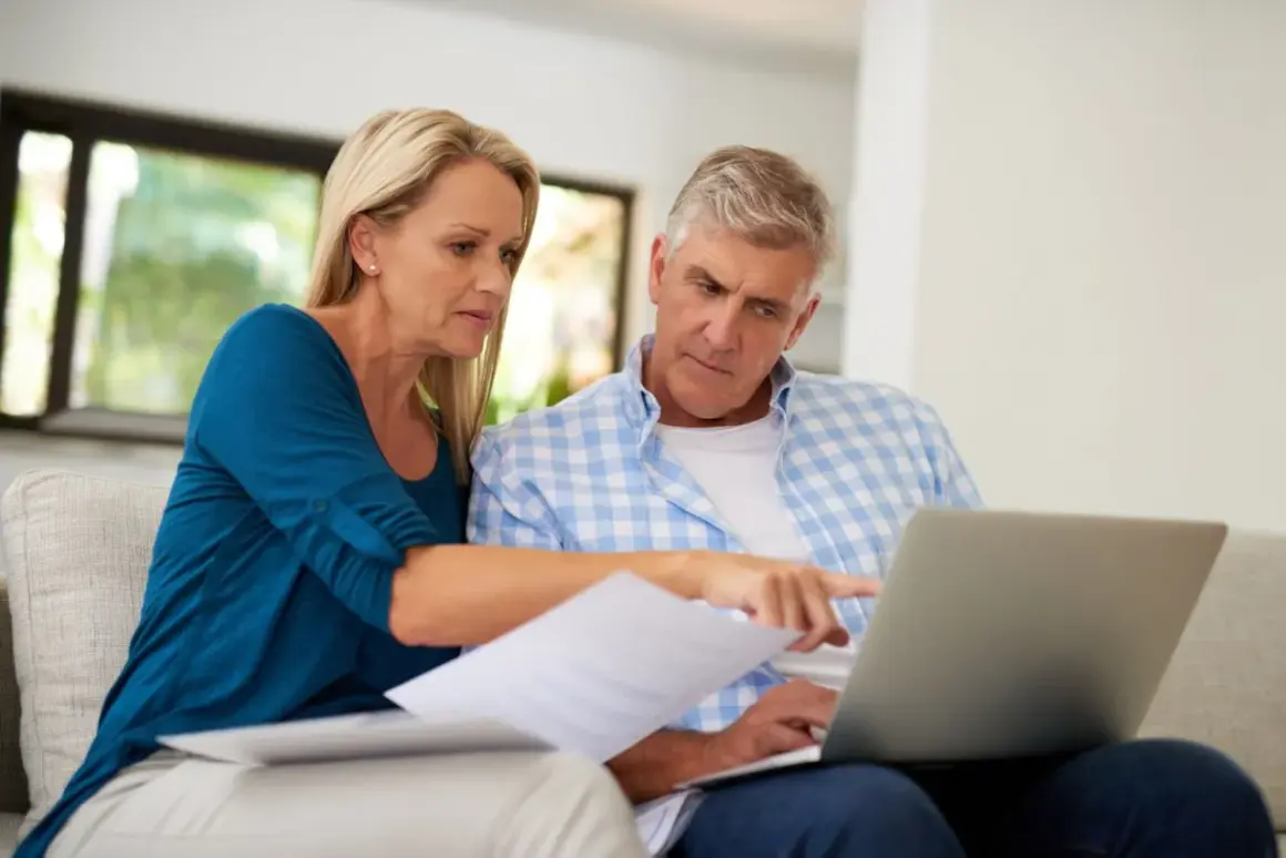 A couple reviews documents and a laptop, discussing their swvxx yield.