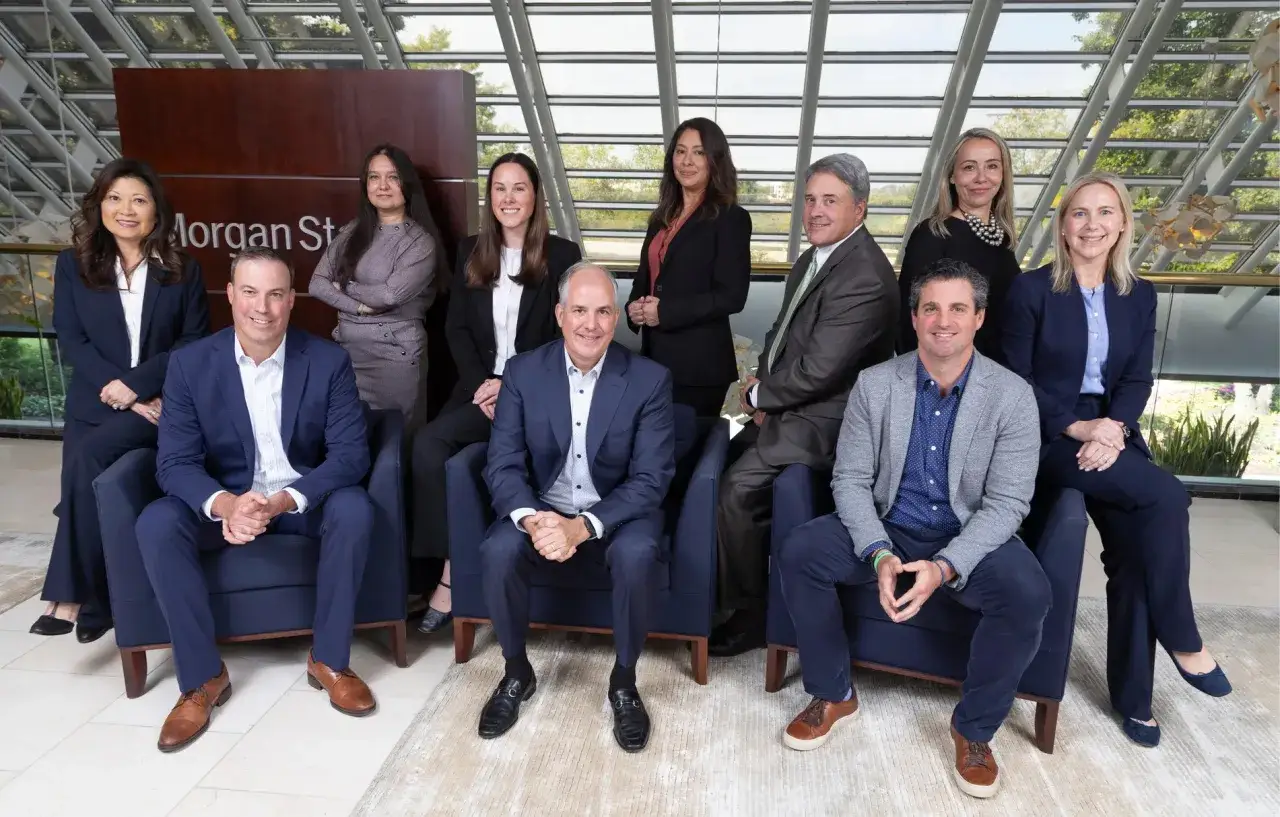 A diverse team of professionals poses in front of a 