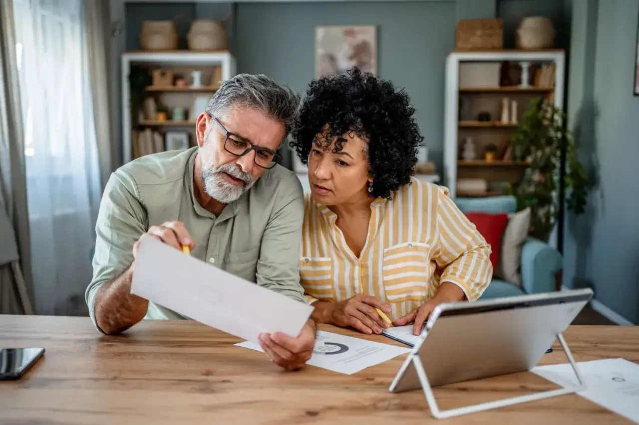 Couple reviewing documents, planning their finances and spousal IRA contributions.