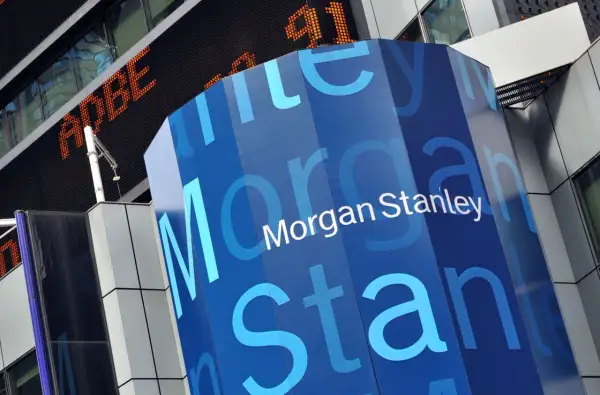 A blue, hexagonal pillar displays the "Morgan Stanley" logo. In the background, an orange digital ticker shows "ADBE" and "91".