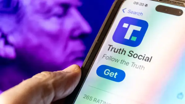 A hand hovers over a smartphone displaying the Truth Social app, with a purple, blurred image of a face in the background, perhaps hinting at the dwac stock price.