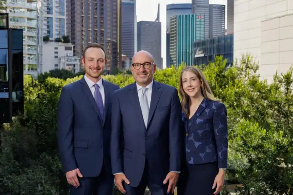 Alan Thomas Morgan Stanley: Three professionals in suits stand before a city skyline.