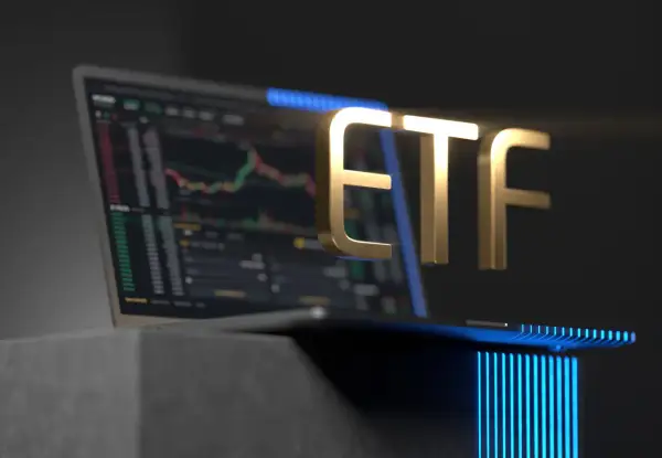 Golden ETF text hovers over a laptop displaying a stock chart, symbolizing investment opportunities.