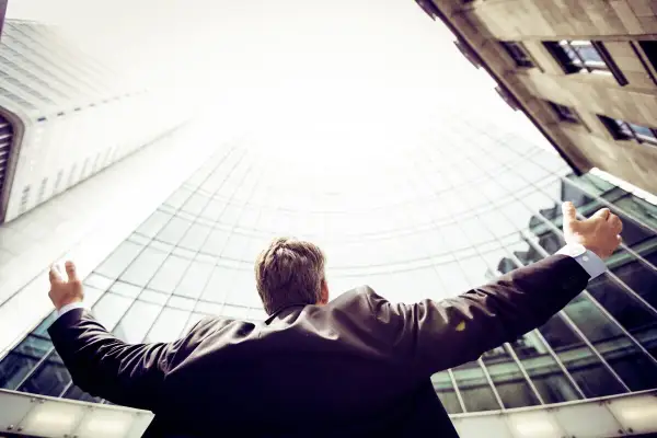 A triumphant Morgan Stanley vice president, arms outstretched, celebrates success against a backdrop of modern skyscrapers.