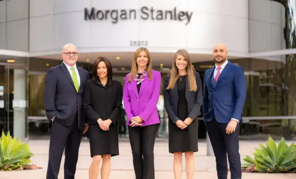 Five professionals stand outside the Morgan Stanley building. The team is ready to help you understand who owns Morgan Stanley and manage your investments.
